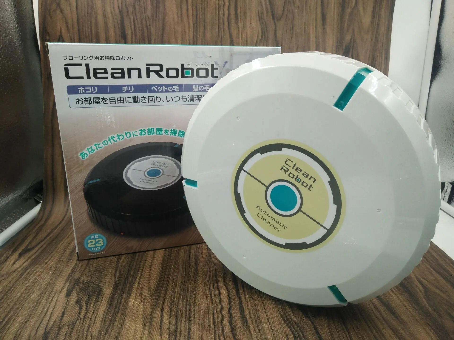 Black or white automatic floor sweeper robot on a hardwood floor.