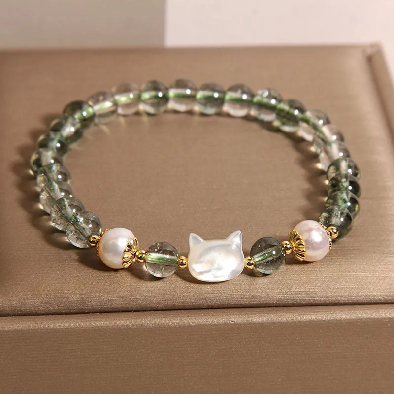 Green Phantom Quartz crystal bracelet with a detailed Shell Kitten charm on a women's wrist.