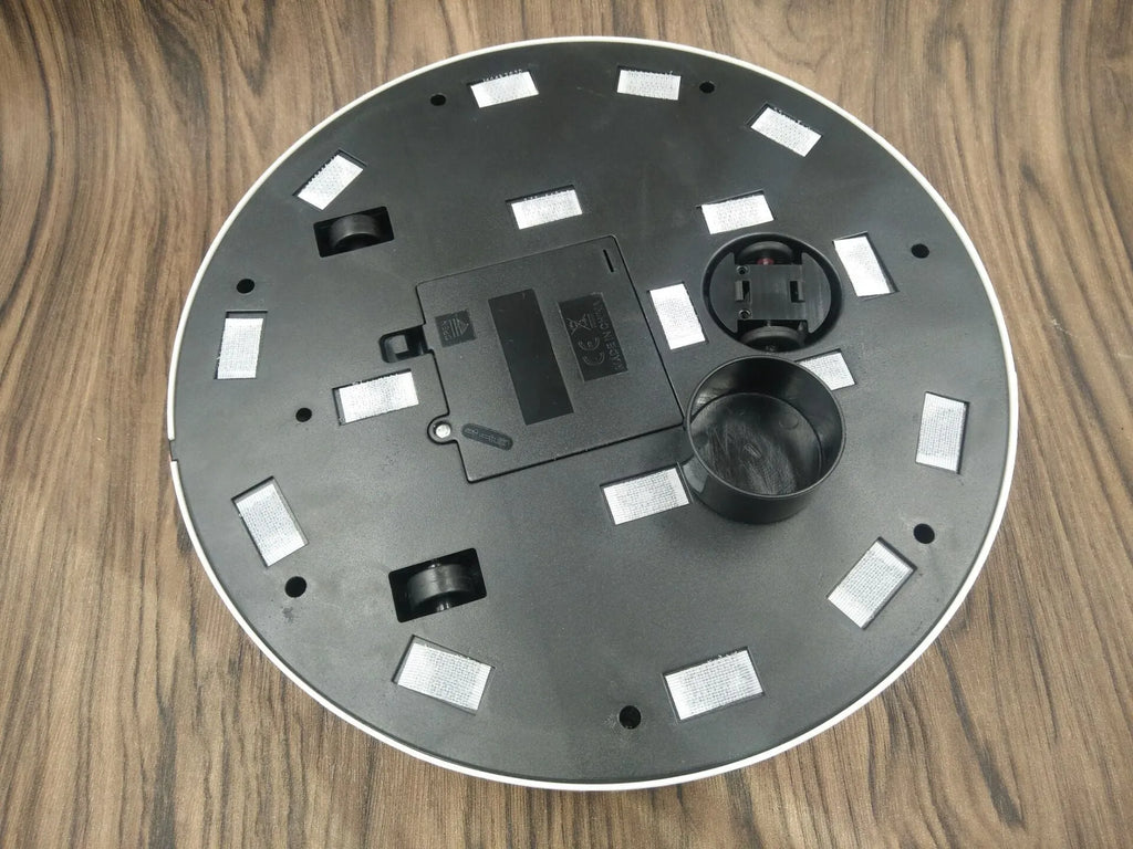 Black or white automatic floor sweeper robot on a hardwood floor.