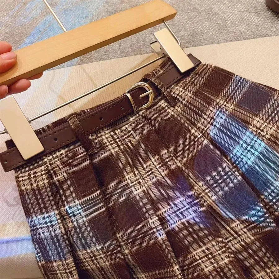 Girls' red and black plaid pleated A-line skirt made from cotton blend fabric.
