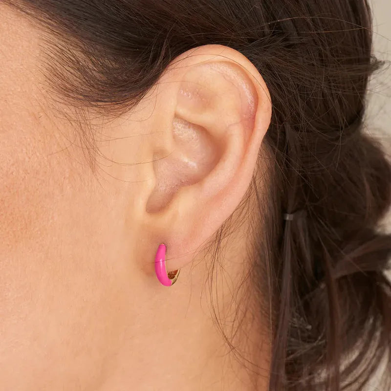 A pair of oval-shaped, U-curved epoxy earrings in a solid colour on a plain background.