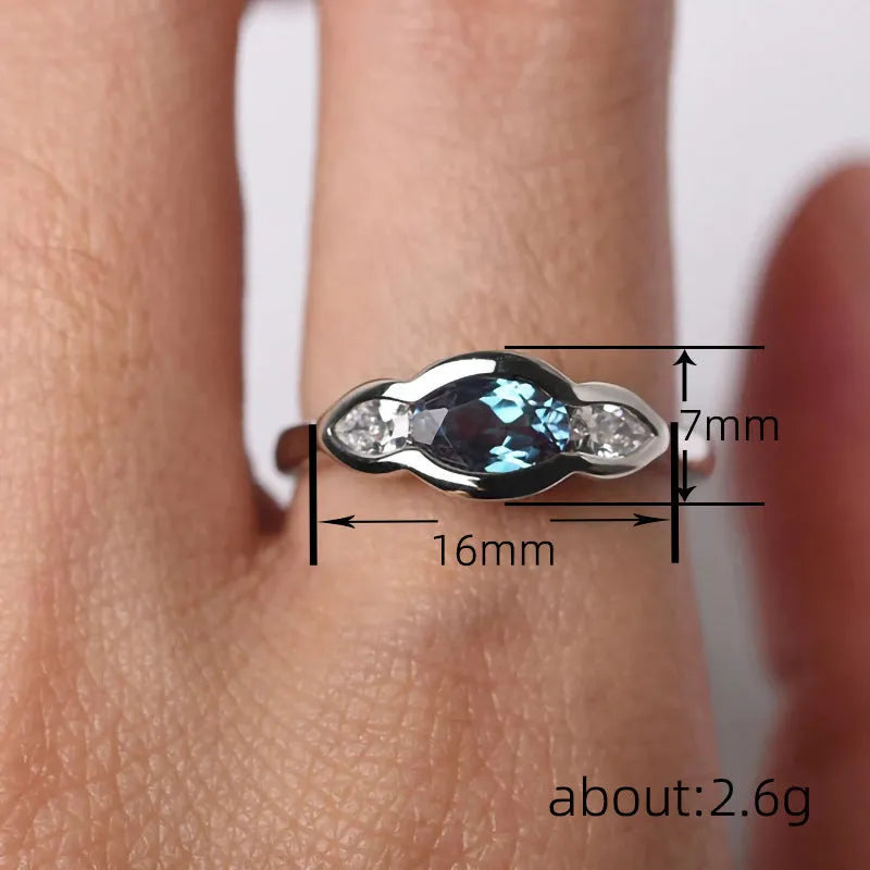 Geometric ellipse copper ring with inlaid zircon stone in a white gold tone colour.