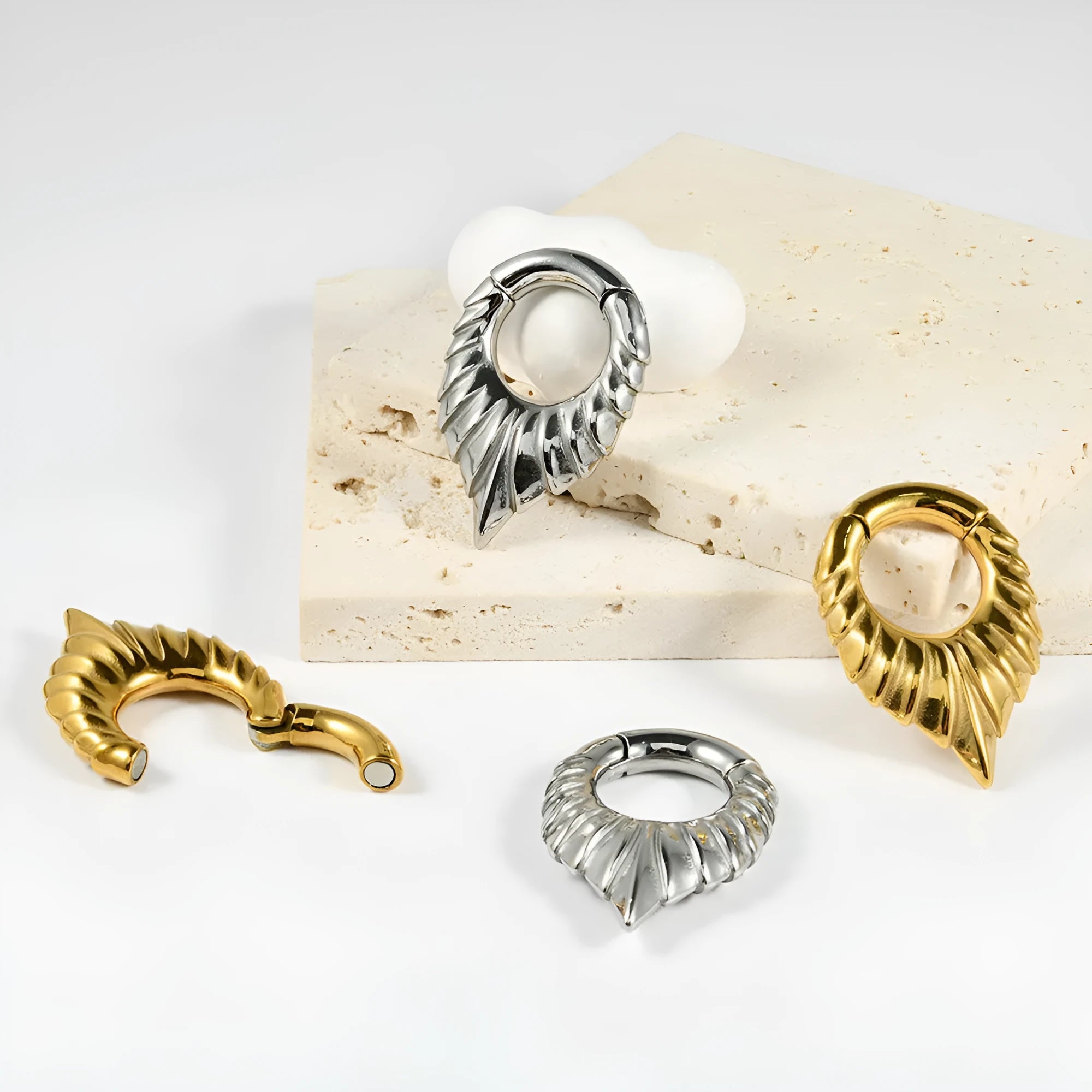 Close-up of a polished silver drop-shaped ear stretcher with a detailed totem pattern, shown against a neutral background.