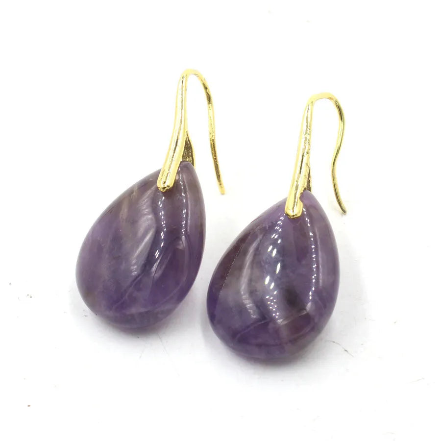 A pair of geometric water drop earrings with a faceted crystal set in electroplated metal.