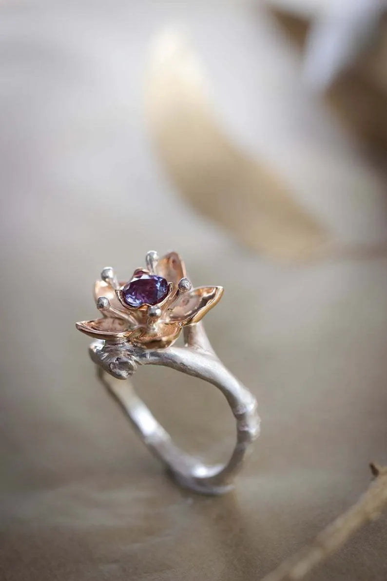 Silver two-tone alloy ring with geometric floral pattern on a simple band.