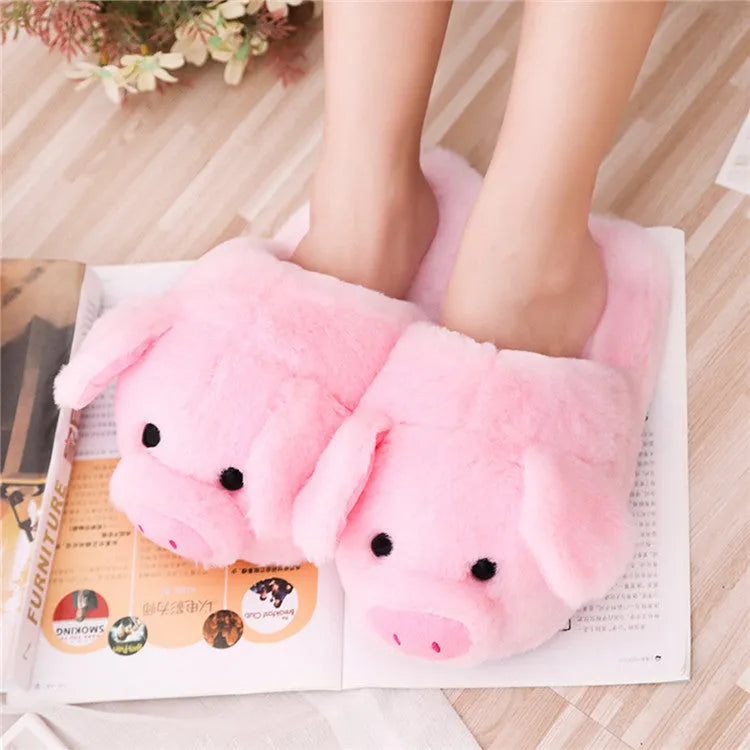 Pink pig-themed plush house slippers for adults on a plain background.