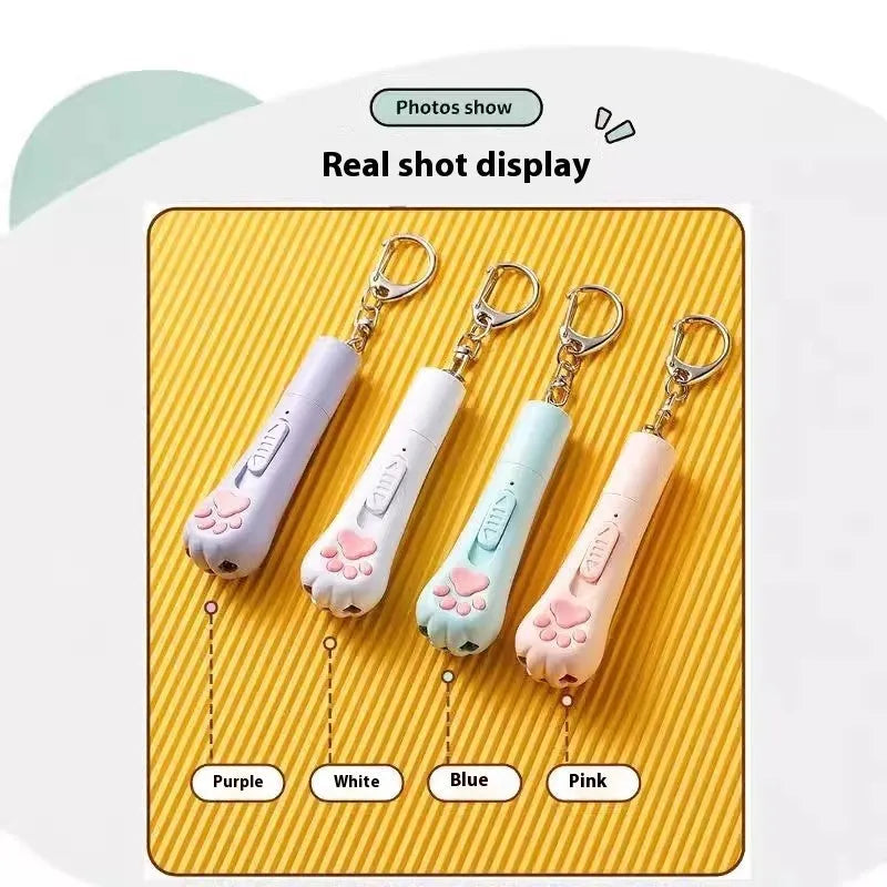 Pink USB-rechargeable cat toy base with a long white feather rotating on a wand, placed on a wooden floor.
