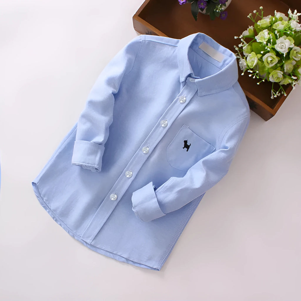 Boy's blue long-sleeved cotton shirt with lapel collar shown on a hanger.