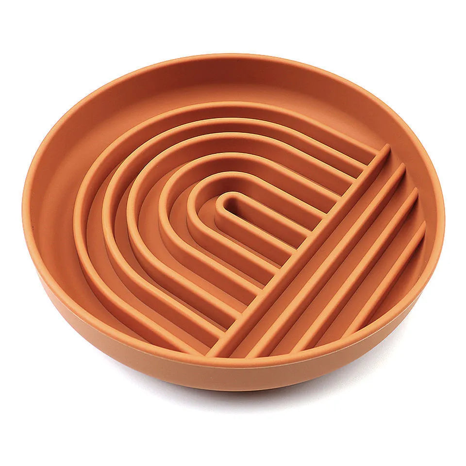 Beige silicone dog slow feeder bowl with ridges, shown next to a grey blue version on a wooden floor.