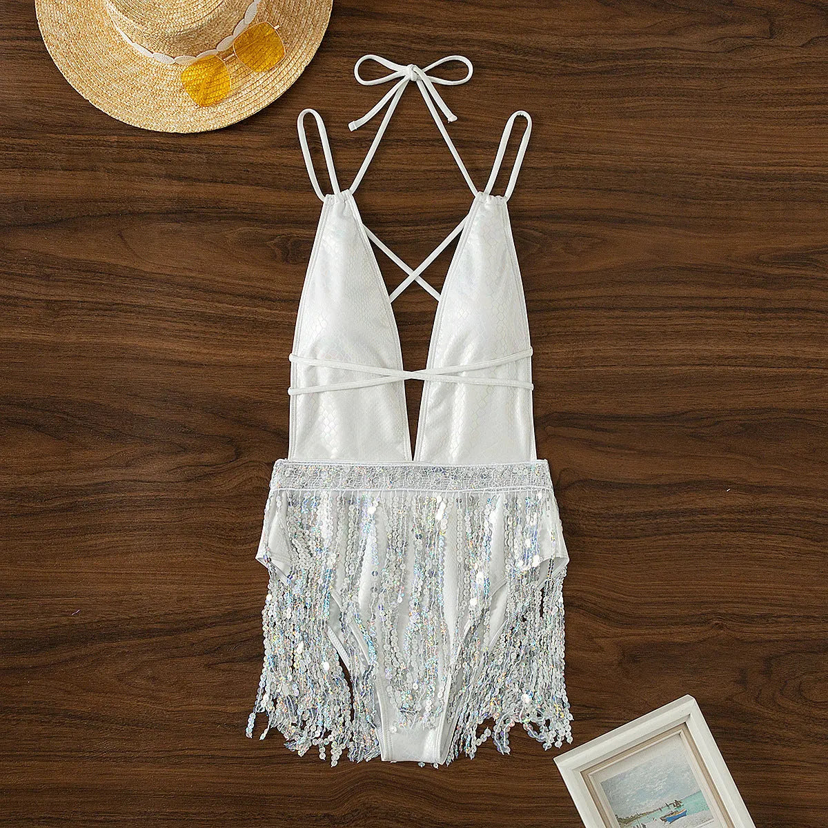 White one-piece swimsuit with deep V neckline and tassel detail on model
