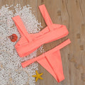 Solid colour orange split bikini swimsuit with high-cut legs on a model by the pool