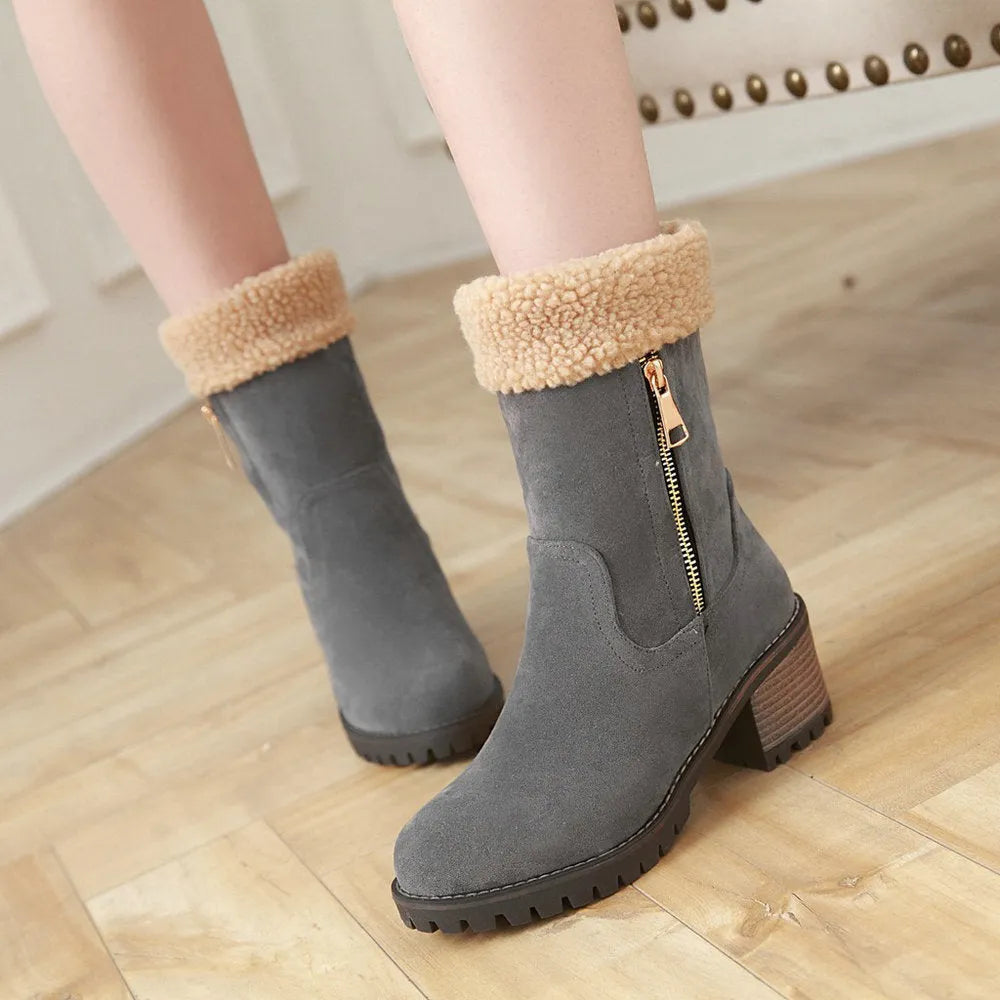 A pair of black snow boots with a plush lining and rubber insole on a winter background.