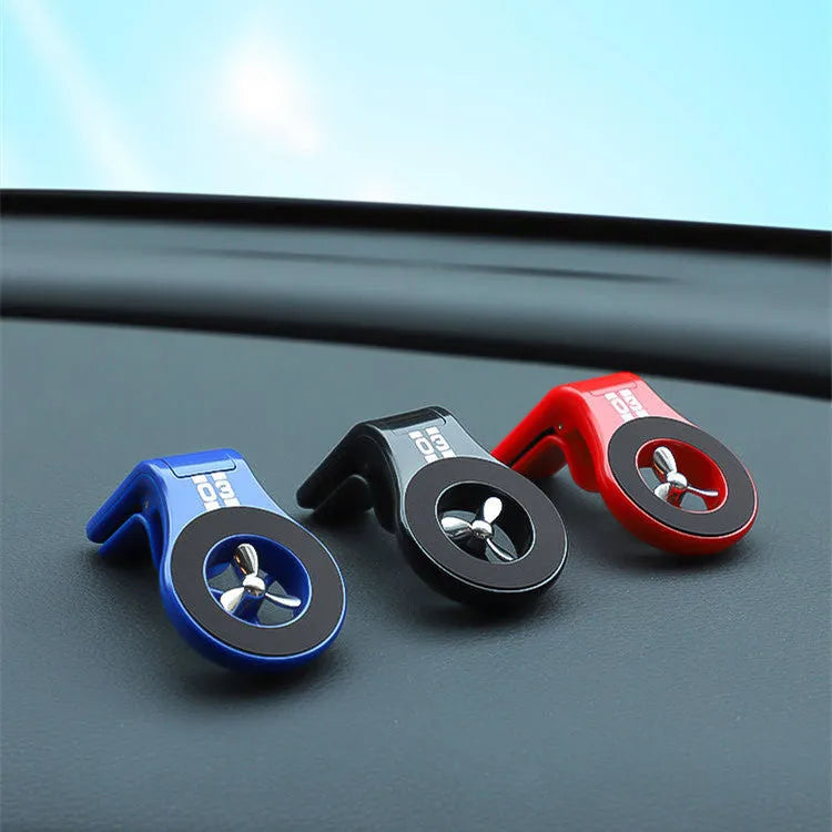 Black magnetic car phone holder clipped to a car air vent, holding a smartphone.