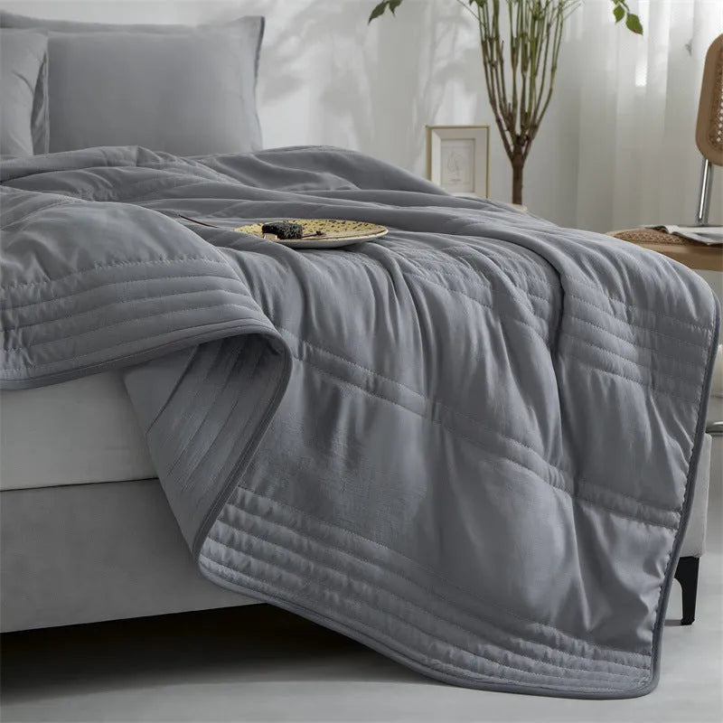Lightweight seersucker summer quilt in various colours on a bed
