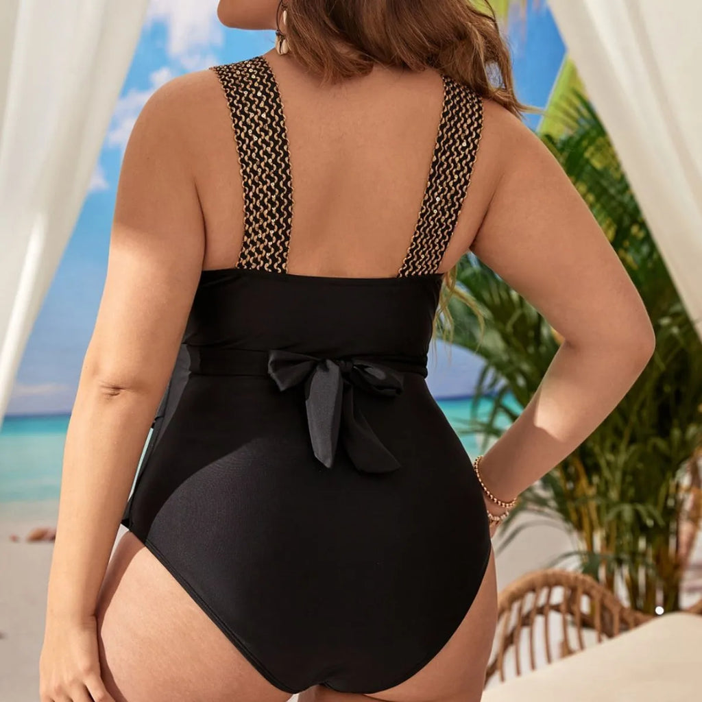 Plus size women's black one-piece swimsuit with sleeveless design and chest pad.