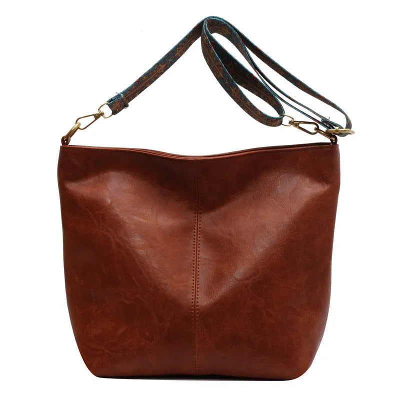 Women's large capacity crossbody bucket bag in PU with nylon lining, available in multiple colours, includes zipper change bag and phone pocket