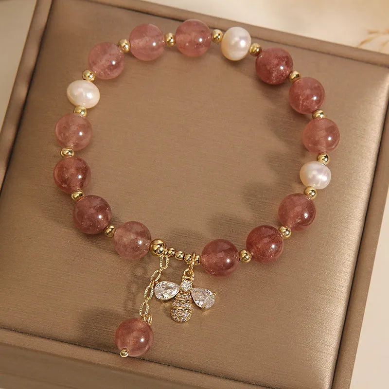 Women's bracelet with strawberry quartz beads, three freshwater pearls, and sparkling zircon details on a metal chain.