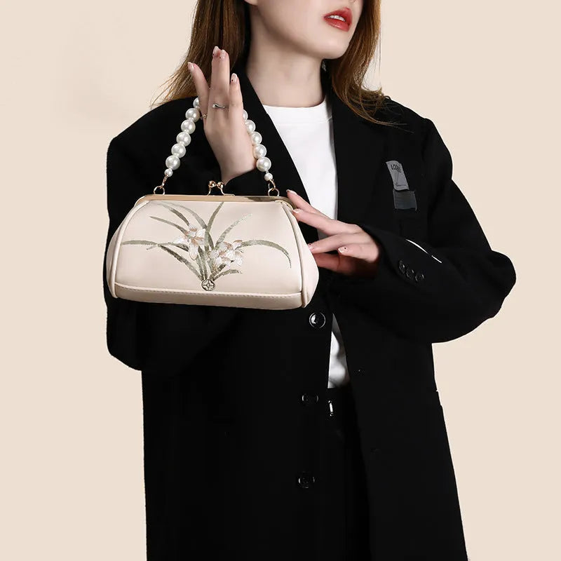 Beige shell-shaped women's shoulder bag with embroidery detail on soft PU leather.