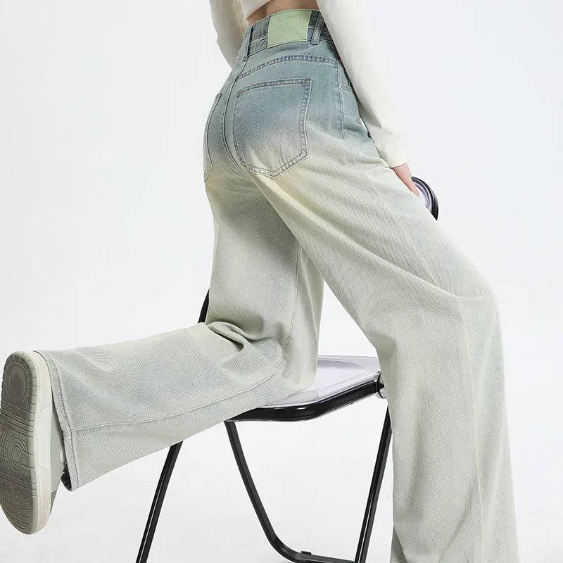 Women's gradient blue straight-leg denim trousers on a hanger, showing wide-leg silhouette.