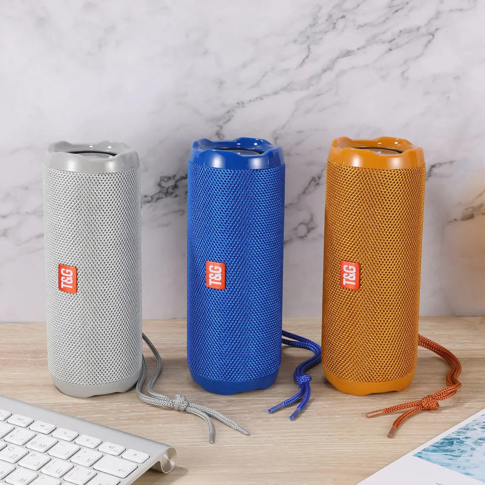 Fabric-covered portable Bluetooth speaker with integrated card holder in multiple colour options.