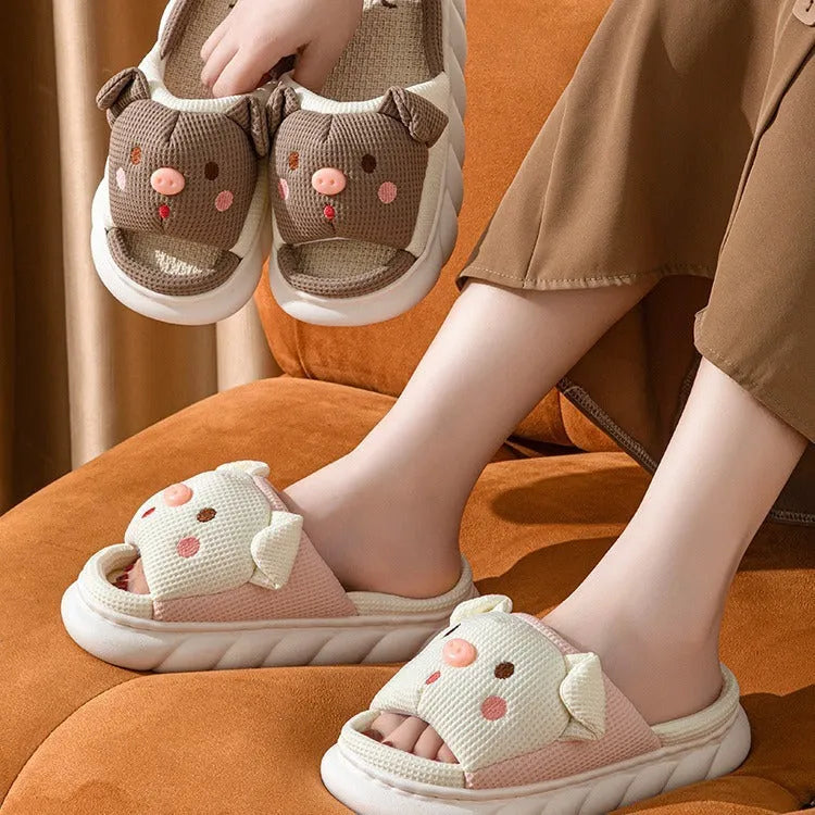 A pair of Piggy Cute linen couple slippers in open toe flip flop style on a plain background.