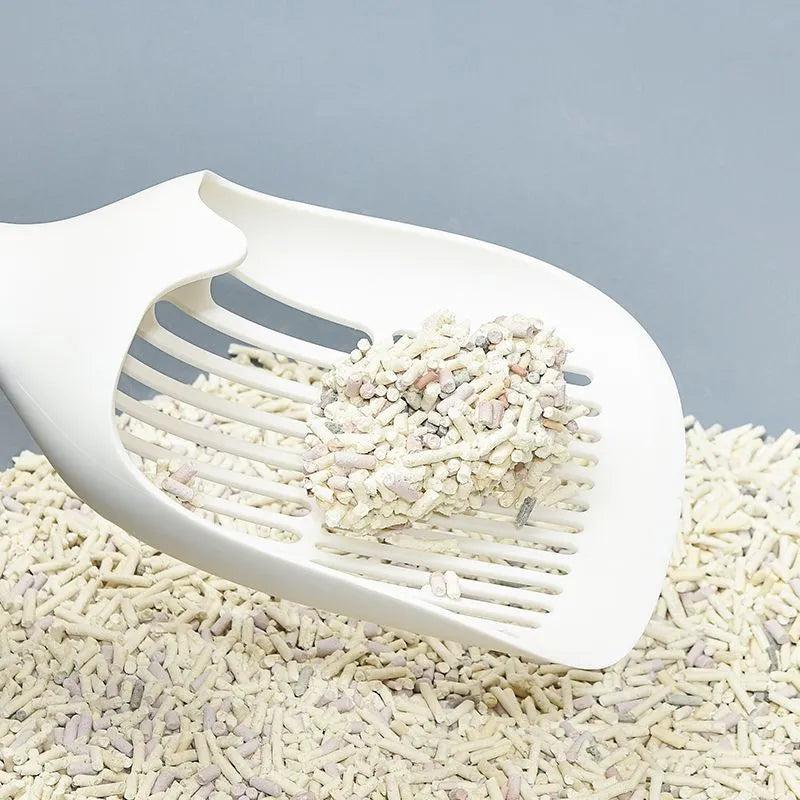 White plastic cat litter scoop with an attached storage base on a white background.