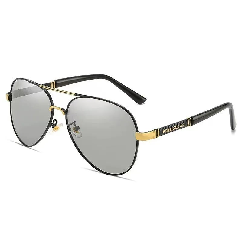 Gold metal frame sunglasses with polarised grey lenses and dragon phoenix temple detail on a table.