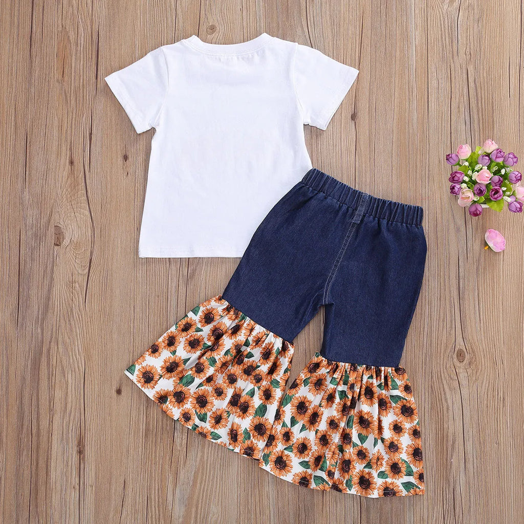 White kids two-piece cotton outfit with short sleeve top and trousers featuring denim torch and sunflower print