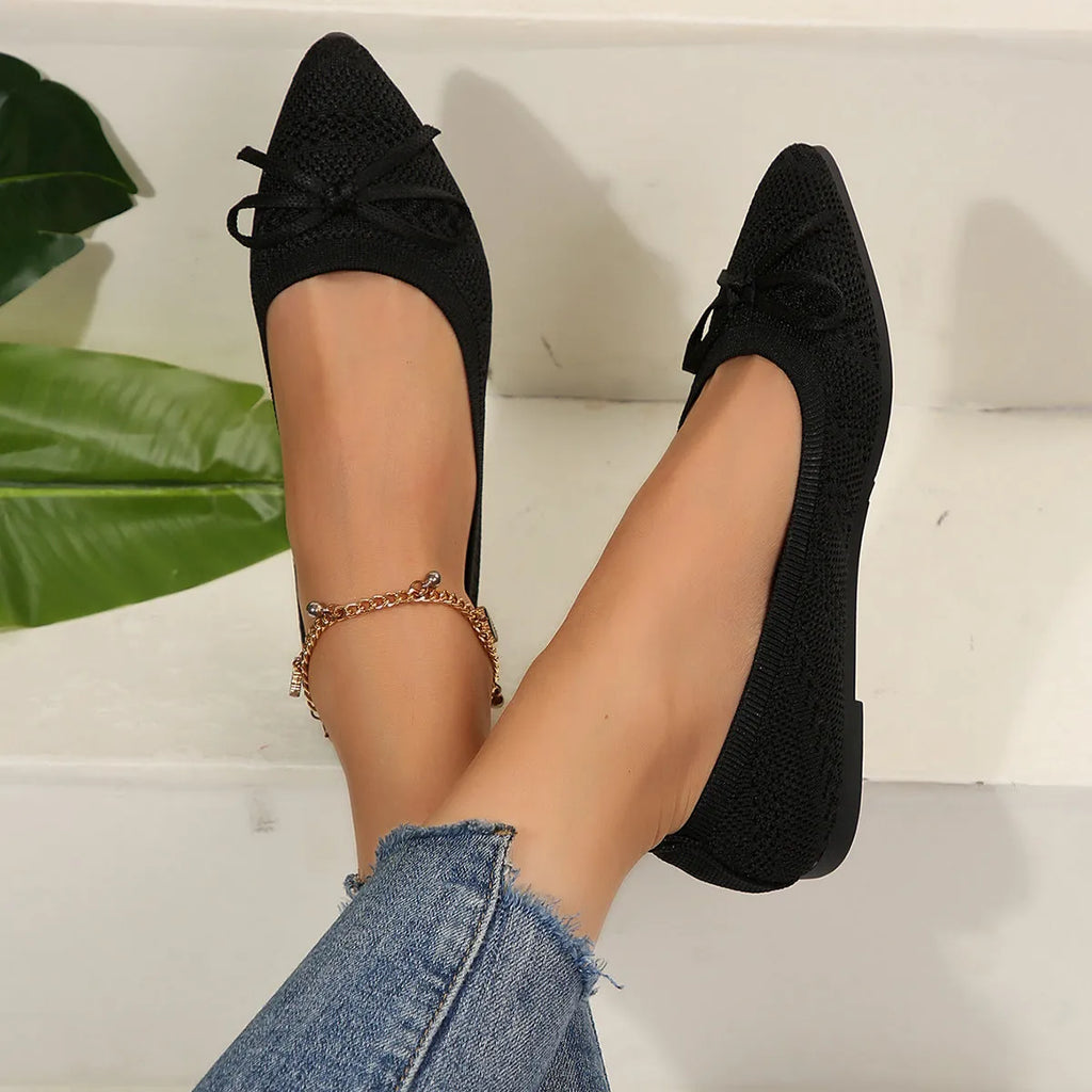 Women's knitted flat loafers with a bow and pointed toe in blue, shown from the side.