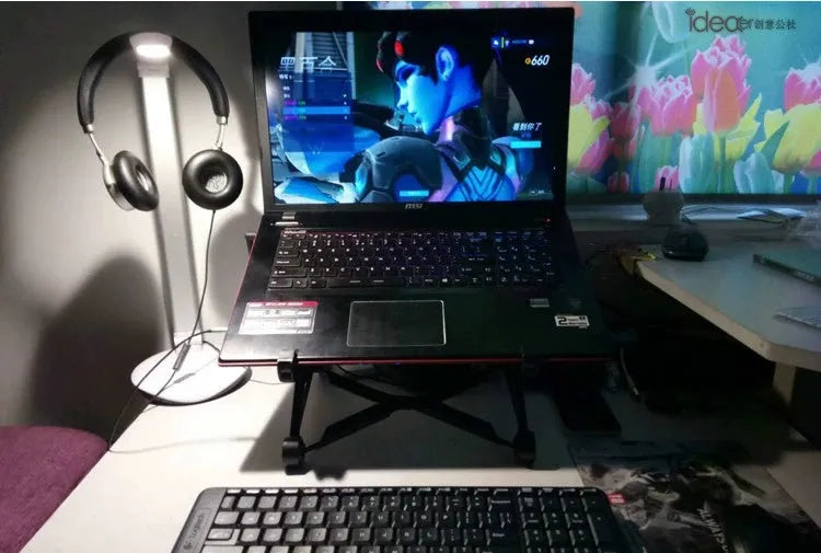 Black foldable portable laptop stand shown with its nylon carry bag and gaskets