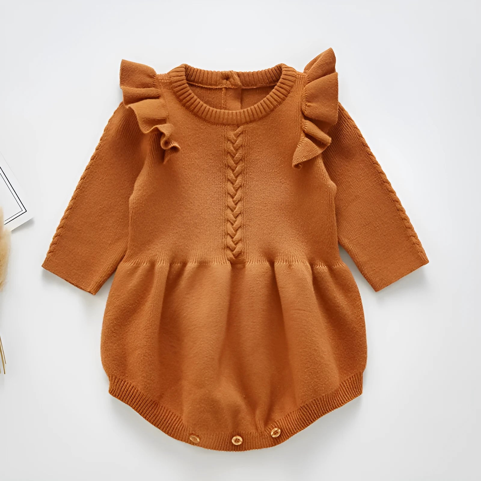 Baby girl wearing a soft pink cotton princess-style romper with a hedging placket.