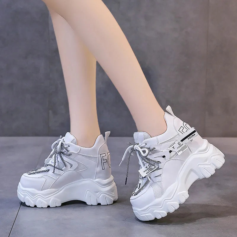 Women's white and black low-top mesh platform shoes with a cross strap and round toe on a rubber sole.