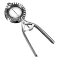 Silver stainless steel manual dumpling maker press tool on a kitchen surface.