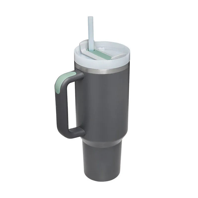 40 oz stainless steel insulated tumbler with a black handle, straw, and grey lid on a wooden table
