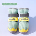 Pair of blue and green breathable mesh dog shoes with thick rubber soles and hook-and-loop straps on a wooden floor.