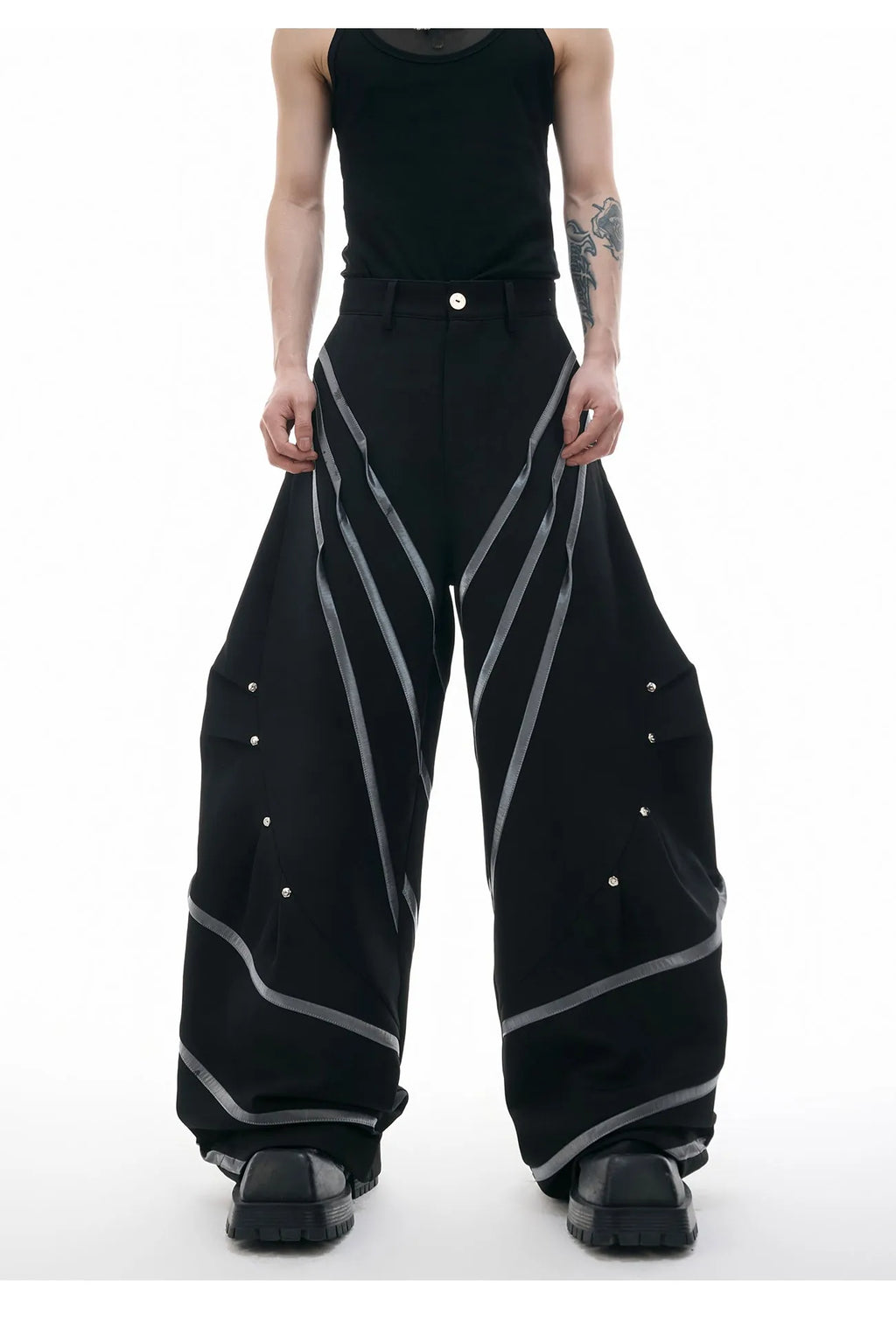 Men's black and white polyester trousers with 3D cutting, metal rivet stripes, and pleated front.