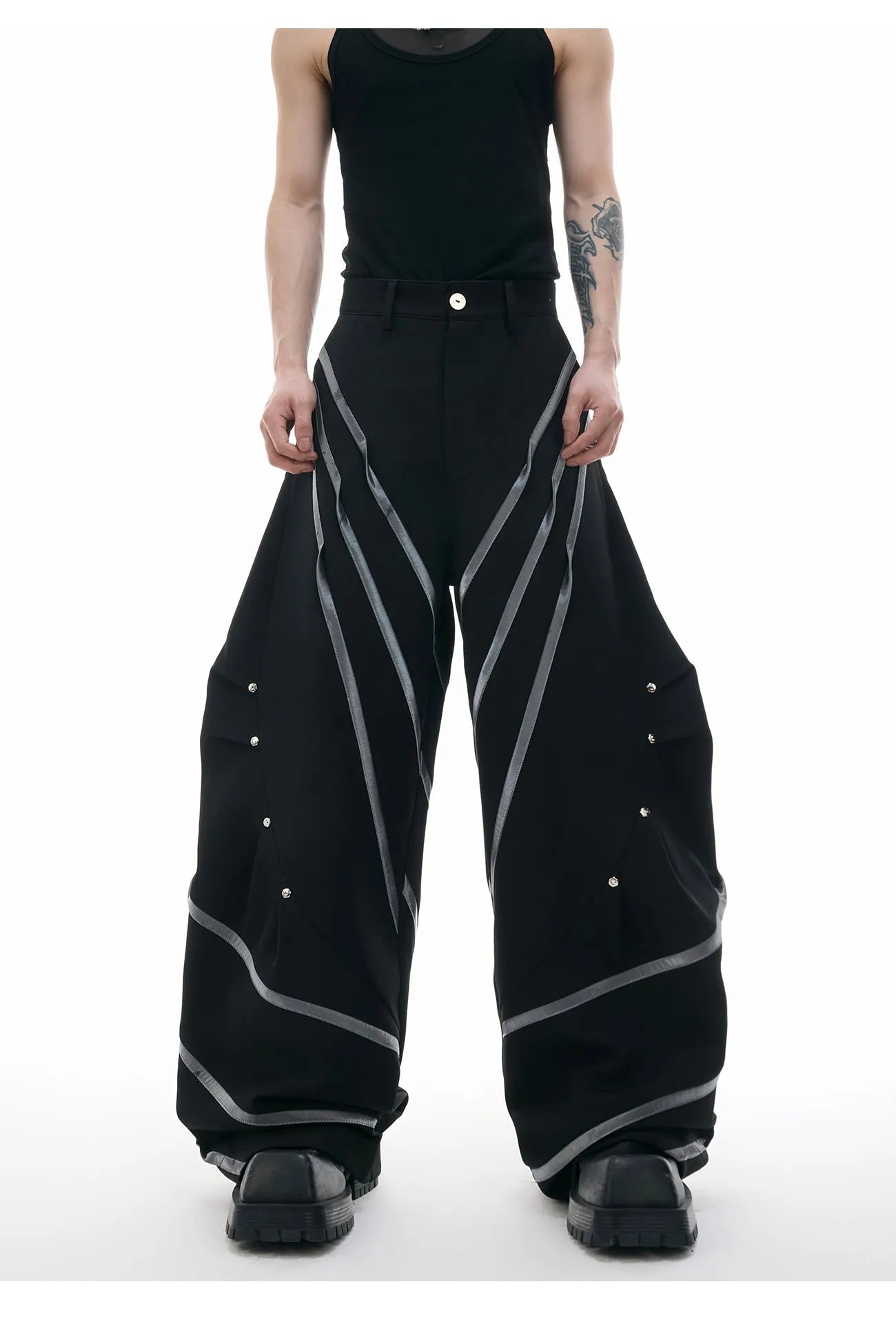 Men's black and white polyester trousers with 3D cutting, metal rivet stripes, and pleated front.