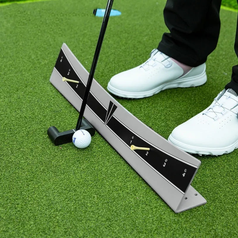 Golf putter resting against the adjustable PVC push rod balancer of the trajectory balance simulator on a carpet.