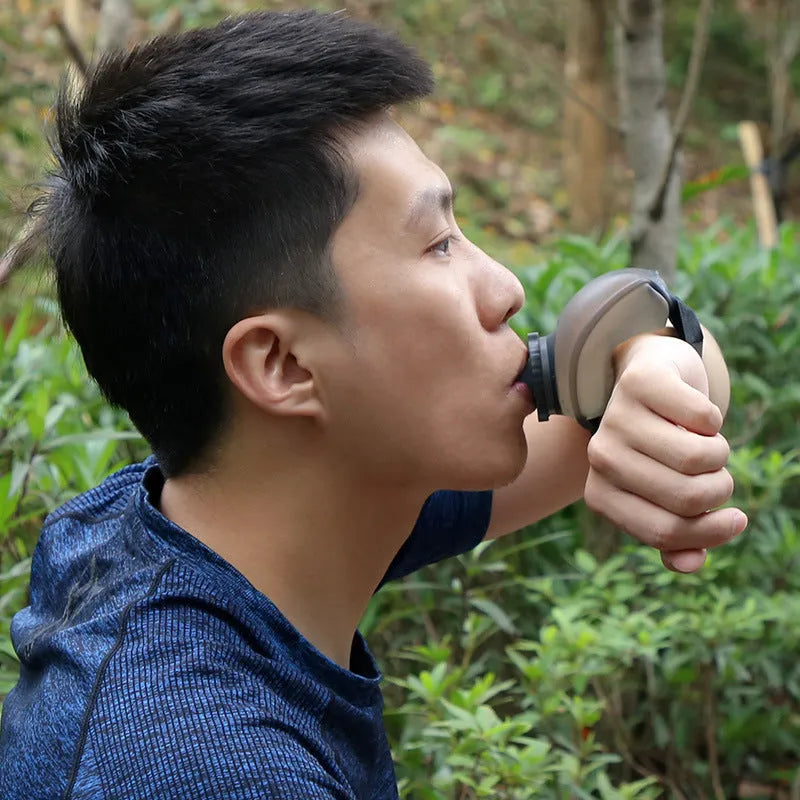 Orange running wrist water bottle with Velcro strap, shown on a person's wrist during exercise.