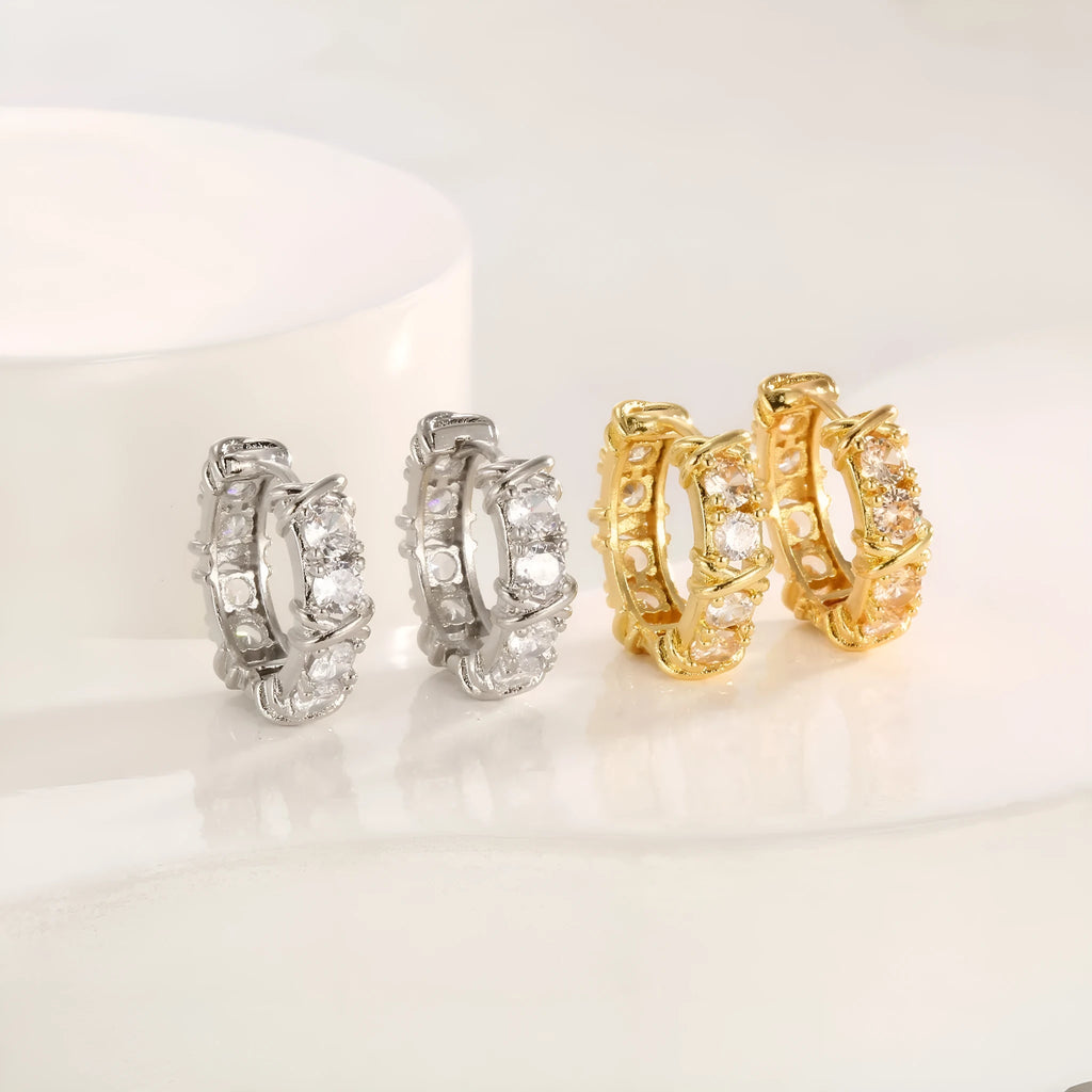 A pair of geometric hexagonal clover cross design earrings with an electroplated gold or silver finish.