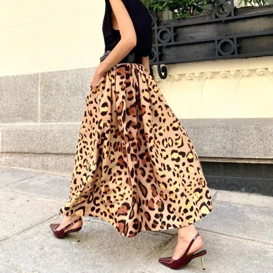 Brown leopard print women's long A-line skirt with a wide flowing hem, shown on a hanger.