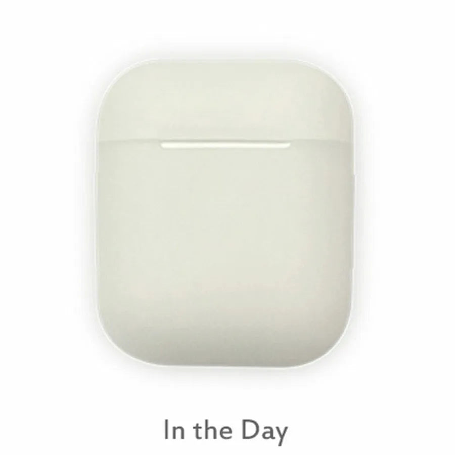 Glow-in-the-dark silicone flip-top protective case for Apple AirPods on a dark background.