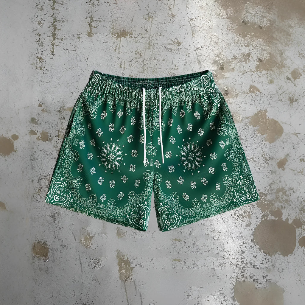 Man wearing loose blue digital print beach shorts made from quick-dry milk silk polyester fabric.