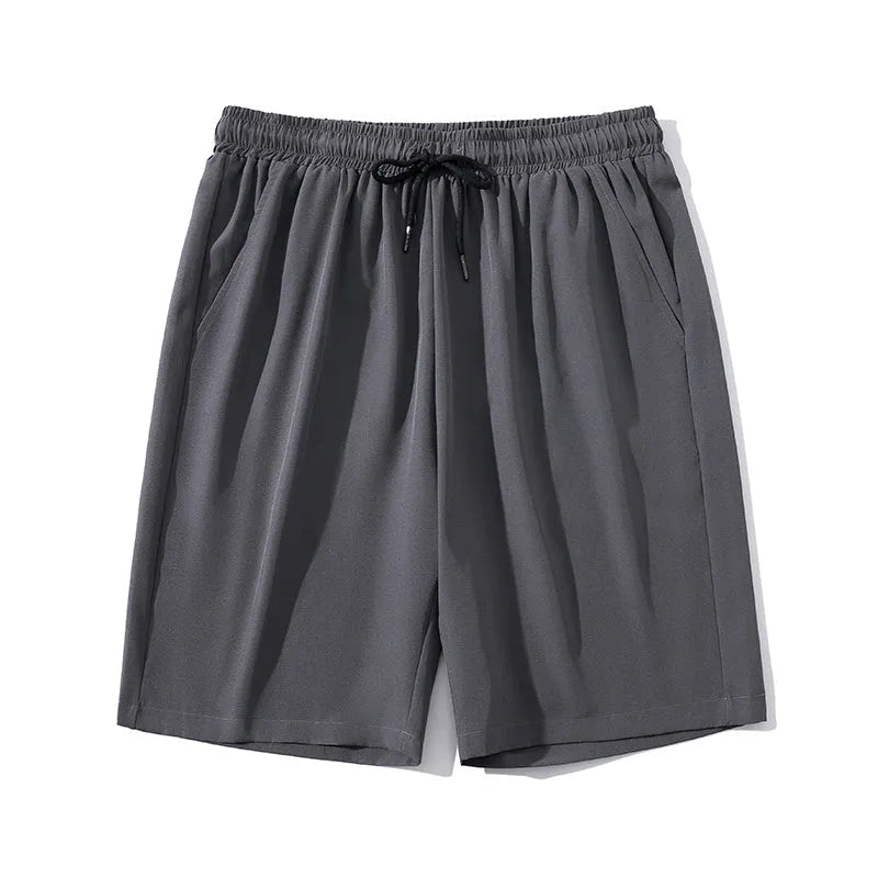 Man wearing grey cropped ice silk sports pants with a straight leg and elasticated waist.