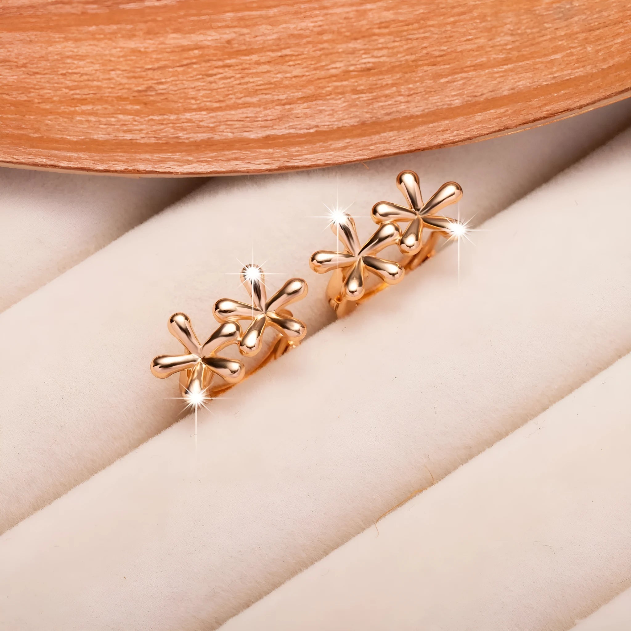 Silver rose gold electroplated circular waterdrop flower earrings with butterfly backs on a grey background.