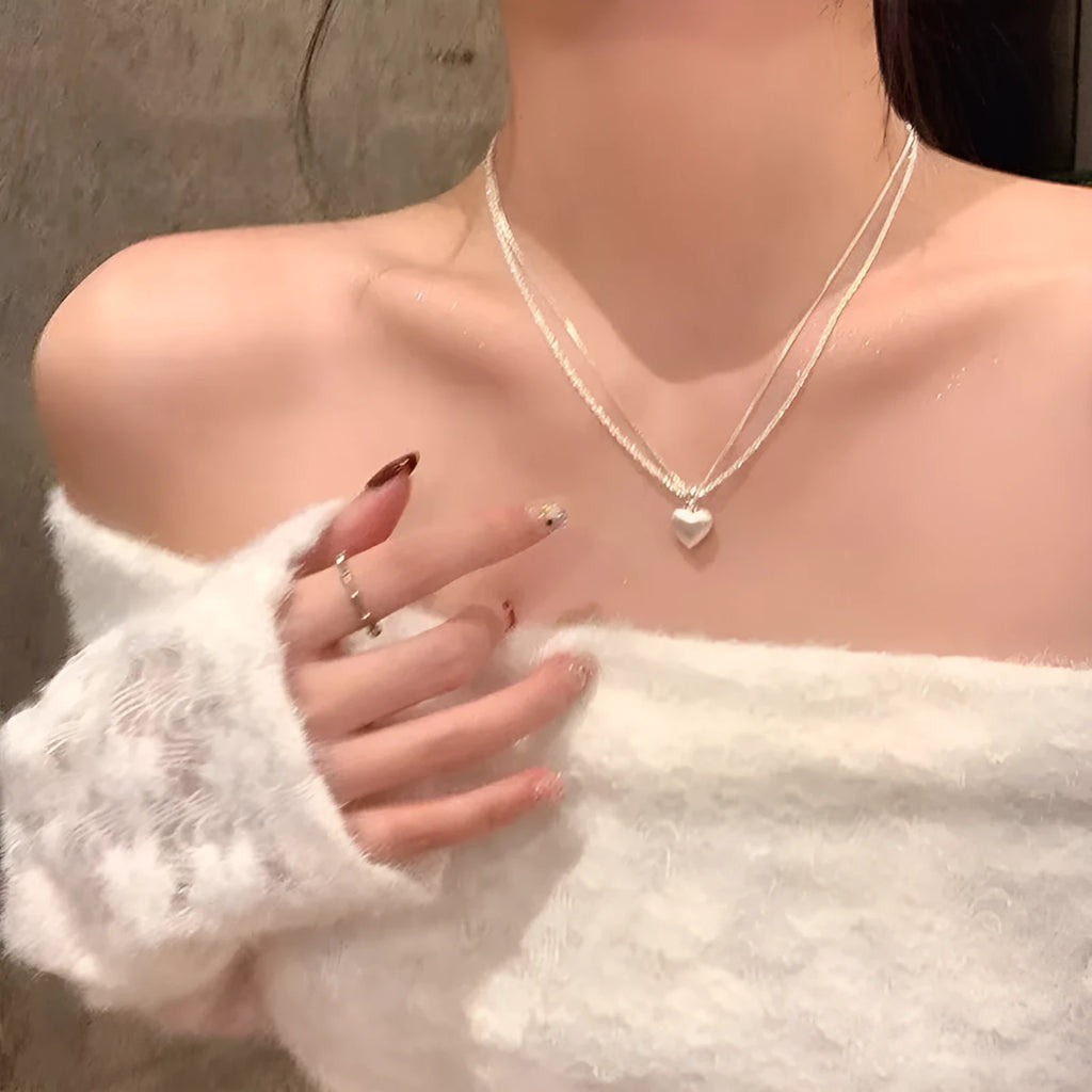 Brushed double-layer heart pendant necklace with adjustable chain on white background