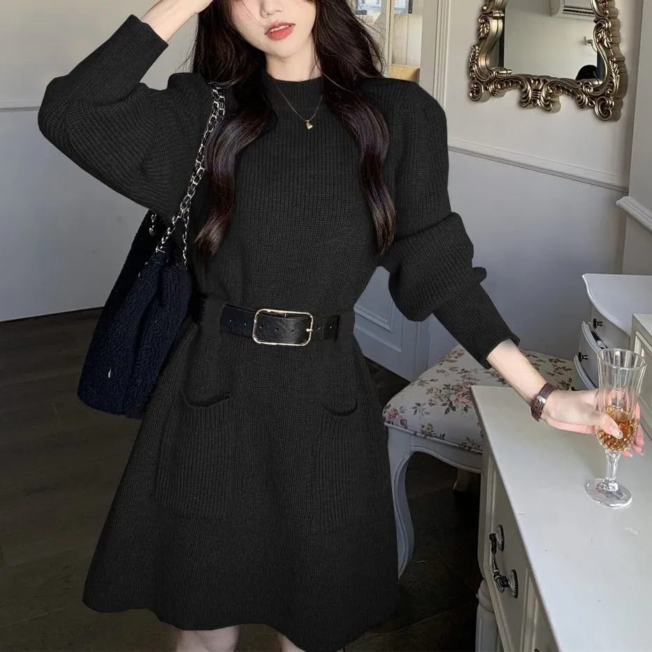 Women's beige loose knitted long sleeve dress with high waist and a black belt.