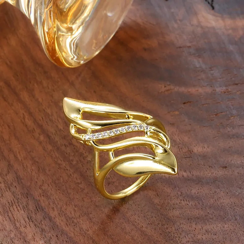 Women's exaggerated curve fashion ring in Q611 gold colour, made from copper with sparkling zircon stone accents.