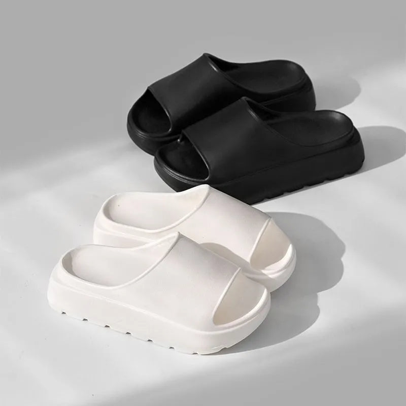 Women's beige fish mouth slippers with a thick light-coloured sole on a wooden floor.