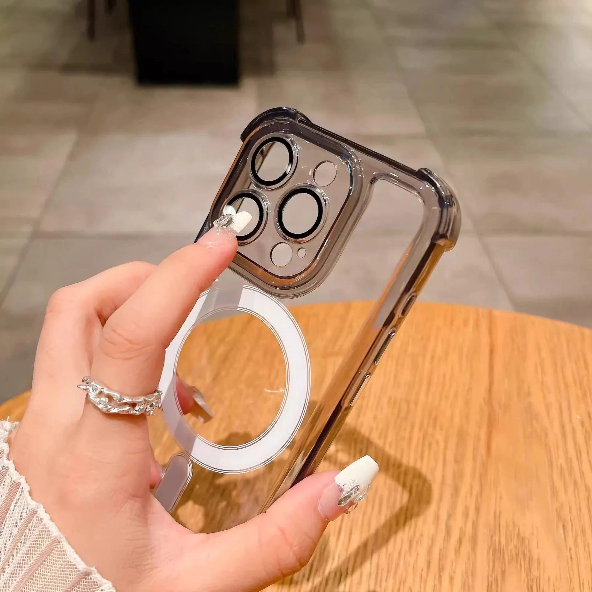 Transparent silicone airbag phone case for iPhone with magnetic ring and built-in camera lens protection.